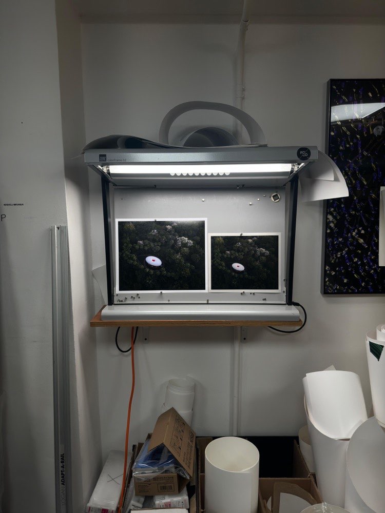 Two aerial print proofs under a color-calibration light box